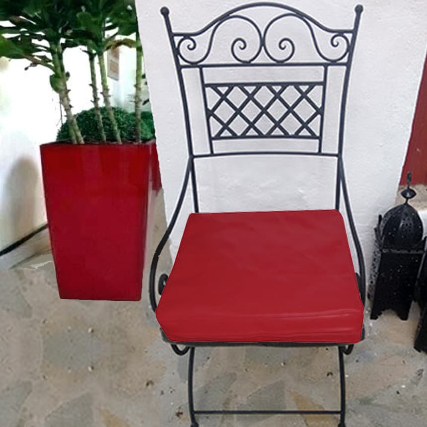 Silla de hierro con brazos y asiento acolchado de color rojo